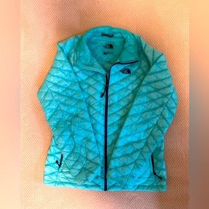 The North Face blueish teal down vest with purple zippers.